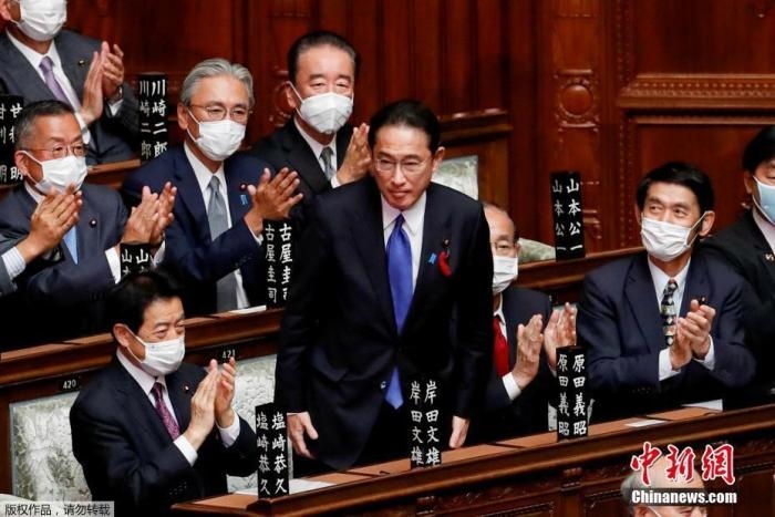 當?shù)貢r間10月4日，日本自民黨總裁岸田文雄經(jīng)過眾院全體會議的首相指名選舉成為第100任首相。圖為岸田文雄（中）起身致謝。
