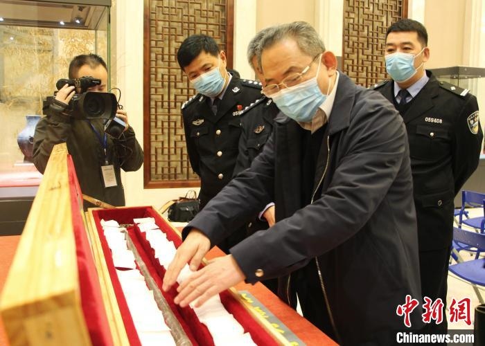 山東博物館館長(zhǎng)鄭同修介紹涉案文物龍首錯(cuò)銀木柲銅杖。　趙曉 攝