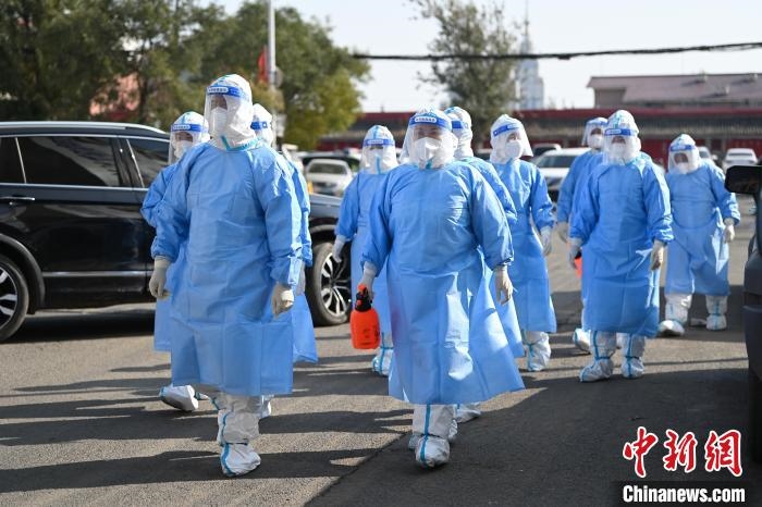 圖為醫(yī)務(wù)人員在封閉小區(qū)做防控工作?！⑽娜A 攝