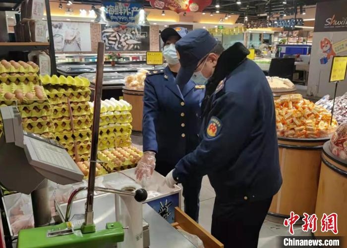 圖為疫情期間，甘肅嘉峪關(guān)市場監(jiān)管局工作人員檢查蔬菜市場?！?柴佳楠 　攝