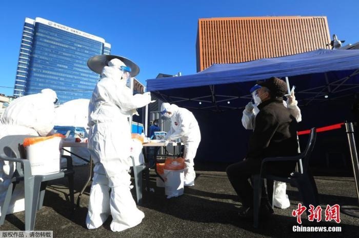 資料圖：韓國首爾，醫(yī)務(wù)人員對市民進行新冠病毒檢測。