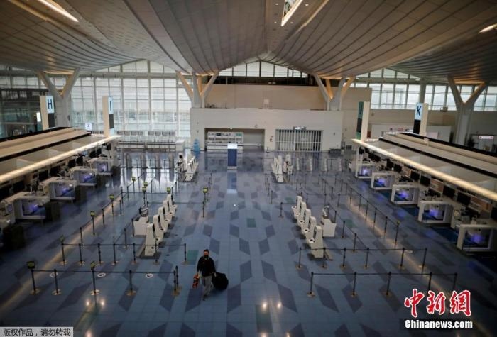 資料圖：日本東京，東京國際機(jī)場，一名乘客在國際航班航站樓的登機(jī)區(qū)。