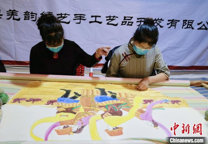 圖為皮繡藝人在市集上“秀”指尖技藝?！●R銘言 攝