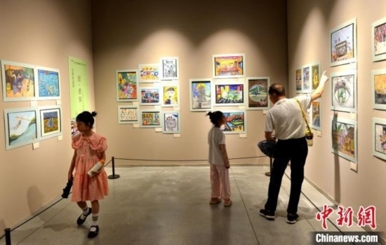 圖為家長(zhǎng)帶著孩子參觀展覽。呂明 攝