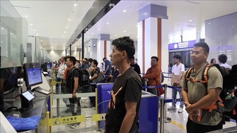 6月13日，乘坐中老鐵路國(guó)際旅客列車的旅客在磨憨邊檢大廳排隊(duì)候檢。李揚(yáng) 攝