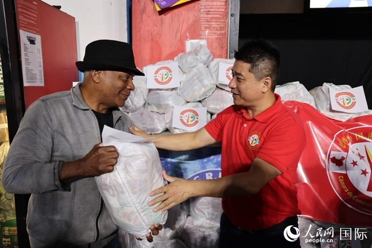 巴西中國浙江商會會長鄭俠茂向社區(qū)居民轉交捐贈物資。人民網(wǎng)記者 時元皓攝