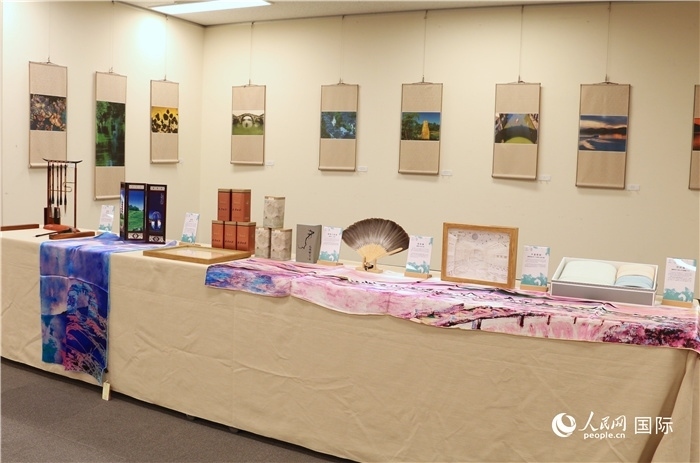 現(xiàn)場展出的馮學(xué)敏攝影作品與湖州市特色工藝品。（人民網(wǎng) 許可攝）