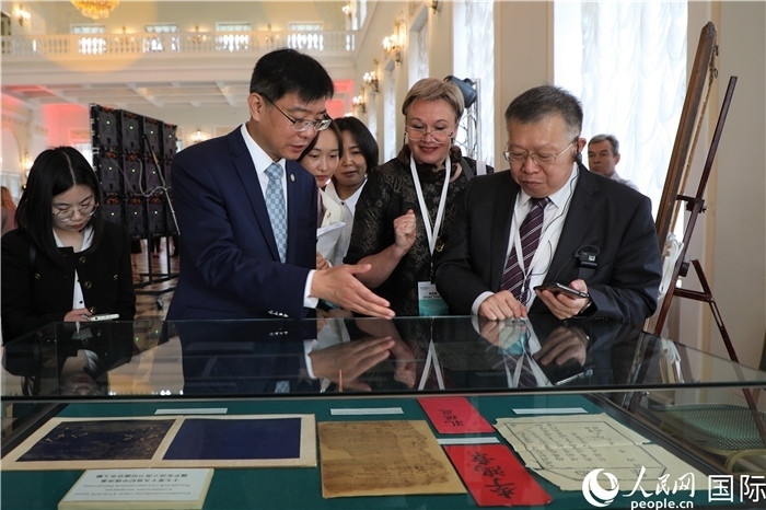 中俄圖書館論壇嘉賓共同參觀由俄羅斯國(guó)立列寧圖書館舉辦的館藏中國(guó)古籍善本圖書展。人民網(wǎng)記者 隋鑫攝）