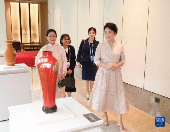 7月27日下午，國家主席習近平夫人彭麗媛在四川成都會見陪同印度尼西亞總統(tǒng)佐科來華出席第31屆世界大學生夏季運動會開幕式并訪華的總統(tǒng)夫人伊莉亞娜。這是彭麗媛和伊莉亞娜欣賞成都特色非遺工藝品。新華社記者 丁林 攝