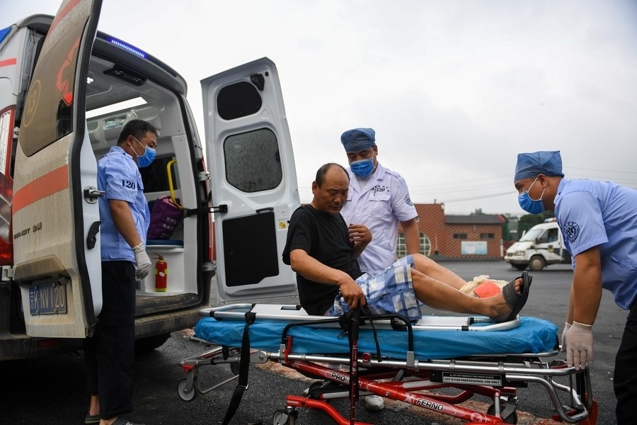 8月1日，在北京市門(mén)頭溝區(qū)妙峰山鎮(zhèn)妙峰山民族學(xué)校臨時(shí)安置點(diǎn)，北京急救中心工作人員在轉(zhuǎn)運(yùn)一名受傷村民。新華社記者 鞠煥宗 攝