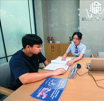 在杭州市臨安區(qū)政務(wù)服務(wù)中心的“為企服務(wù)中心”，黨員志愿者（右）解答企業(yè)主的疑問（2023年7月7日攝）。徐昱攝/本刊