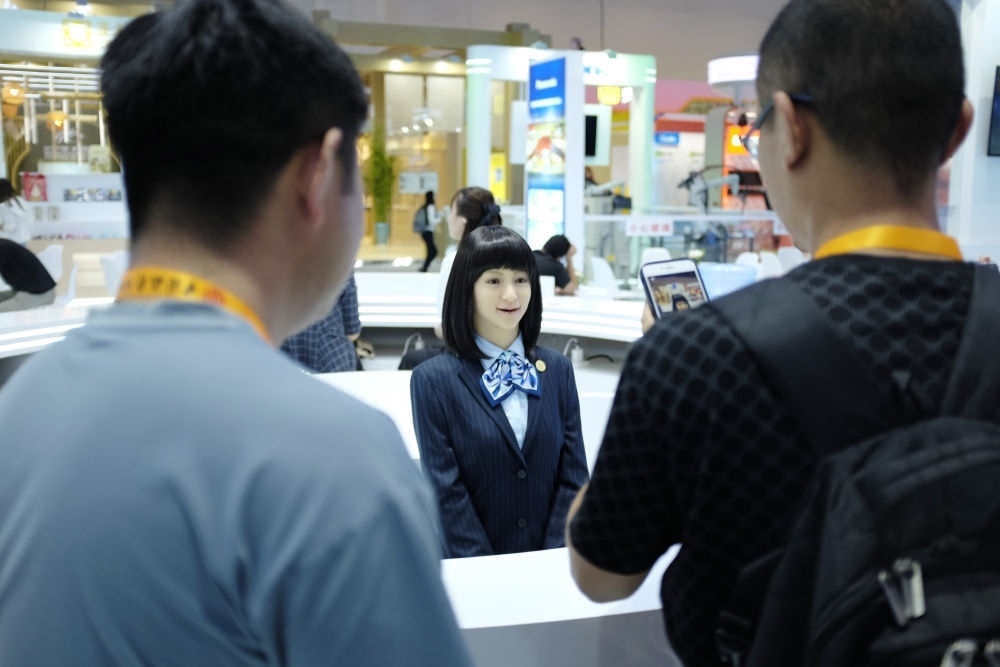 9月1日，媒體記者在國(guó)家會(huì)議中心與服務(wù)機(jī)器人互動(dòng)。新華社記者 劉夢(mèng)琪 攝