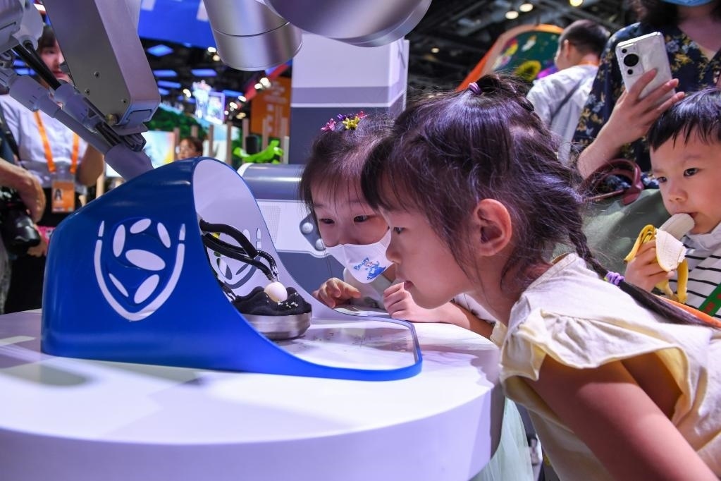 9月3日，幾名小朋友在國(guó)家會(huì)議中心觀看單孔腔鏡手術(shù)機(jī)器人展示。新華社記者 鞠煥宗 攝