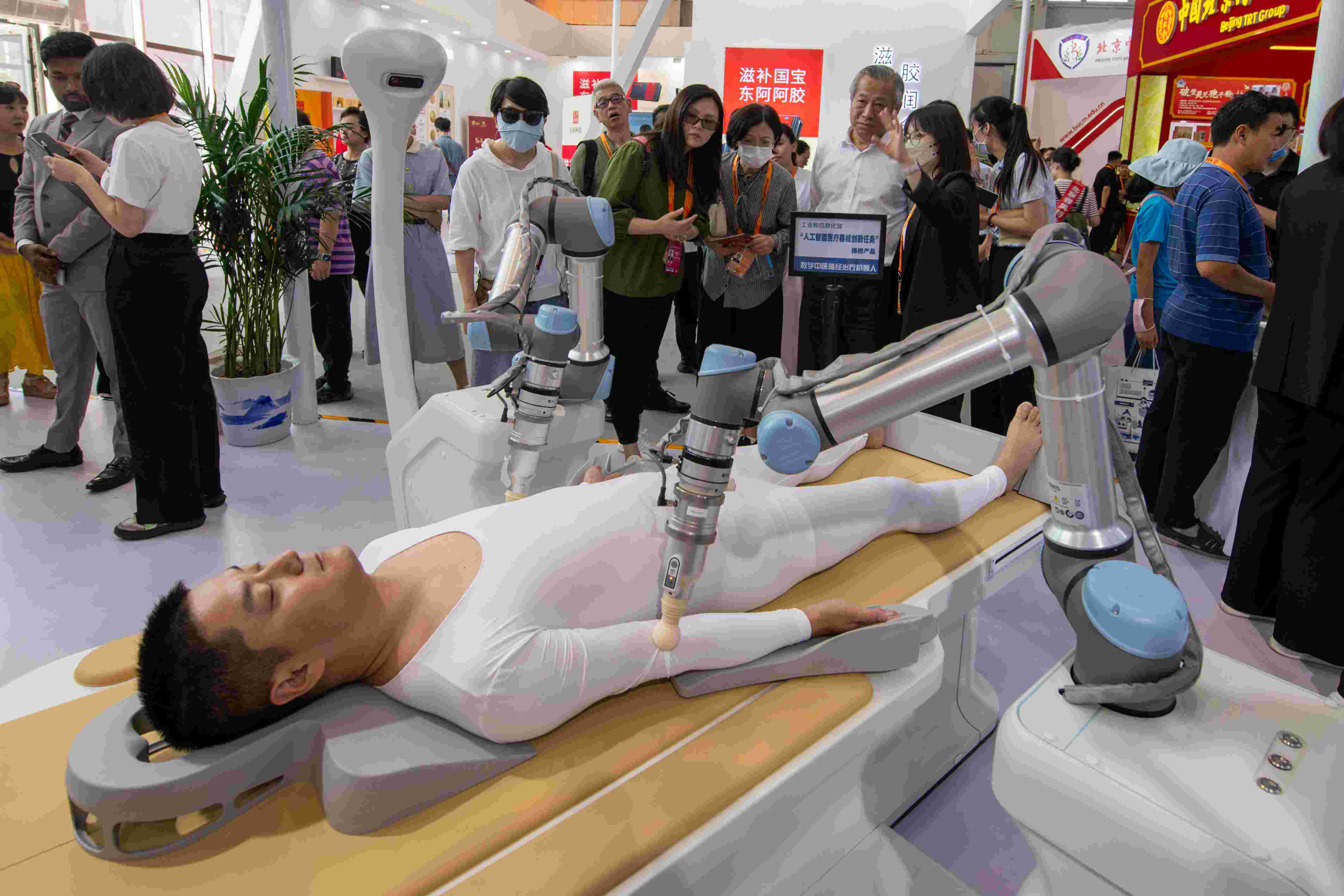 在位于首鋼園的健康衛(wèi)生服務(wù)展區(qū)，觀眾正在參觀數(shù)字中醫(yī)循經(jīng)治療機(jī)器人。人民網(wǎng)記者 翁奇羽攝