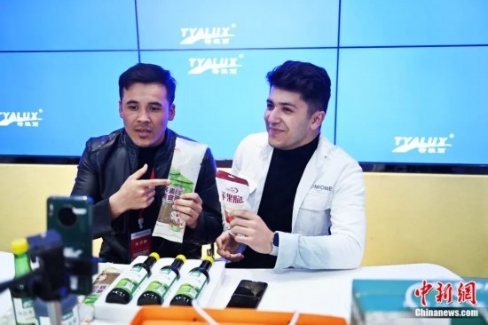 2023年3月，甘肅省慶陽市環(huán)縣電商創(chuàng)業(yè)孵化基地內(nèi)，來自蘭州文理學(xué)院的塔吉克斯坦留學(xué)生正在協(xié)助主播直播帶貨當(dāng)?shù)剞r(nóng)特產(chǎn)品。李亞龍 攝