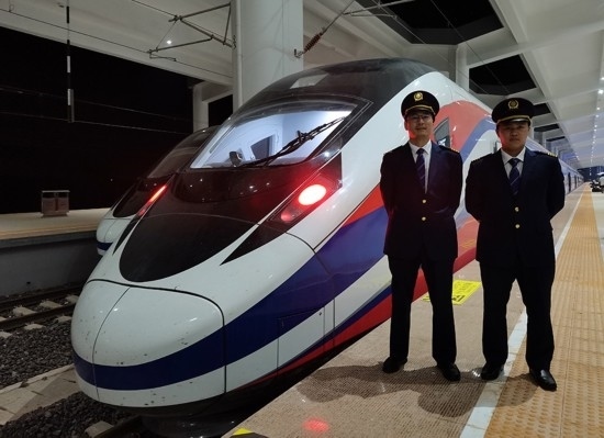 劉銀能（右一）與中國師父鄔俊鴻在動(dòng)車組前合影。受訪者供圖