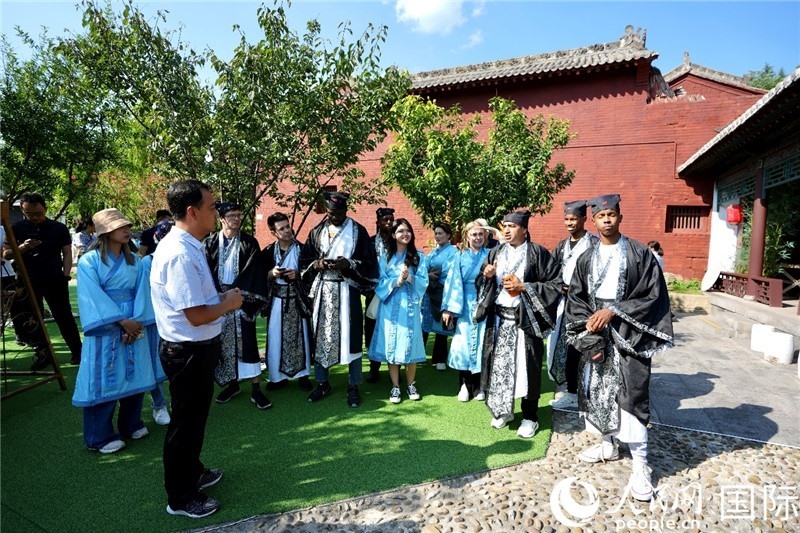 圖為選手們聽導(dǎo)游講解。人民網(wǎng) 盧鵬宇攝