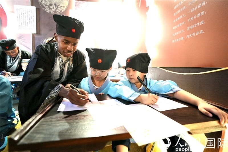 圖為選手與同學(xué)們一起寫書法。人民網(wǎng) 盧鵬宇攝