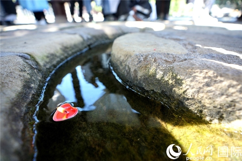 圖為水渠里流過的“桃心”蠟燭。人民網(wǎng) 盧鵬宇攝