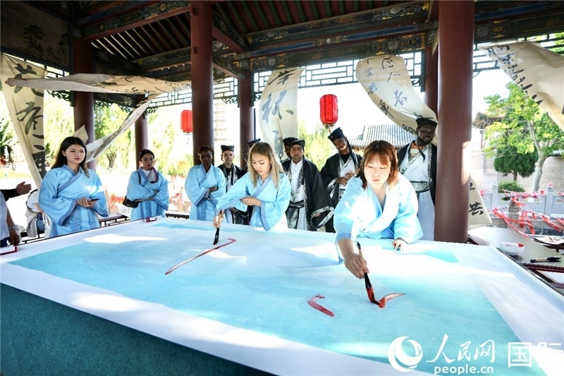 選手們提筆書寫“家園”二字。人民網(wǎng) 盧鵬宇攝