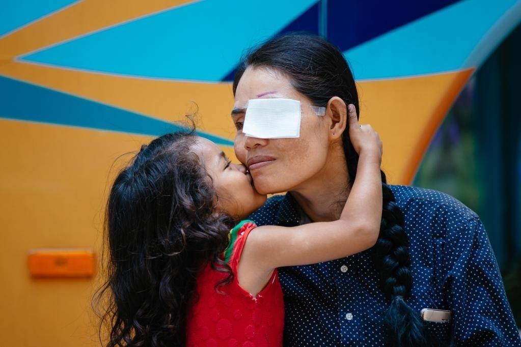 2019年3月15日，在柬埔寨磅湛省醫(yī)院，即將接受白內(nèi)障手術(shù)的患者孫美樂接受女兒的親吻祝福。在接受了中國醫(yī)療隊(duì)的白內(nèi)障義診手術(shù)后，她的視力逐步恢復(fù)，生活有了新的光明和希望。