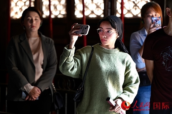 選手顏青（蘇丹）用手機(jī)記錄所見所感。人民網(wǎng) 盧鵬宇攝