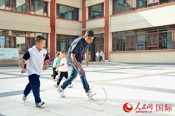 來(lái)自巴基斯坦的沙杰在滾鐵環(huán)。人民網(wǎng) 盧鵬宇攝