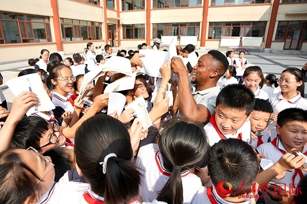 孩子們和選手互動(dòng)簽名。人民網(wǎng) 盧鵬宇攝