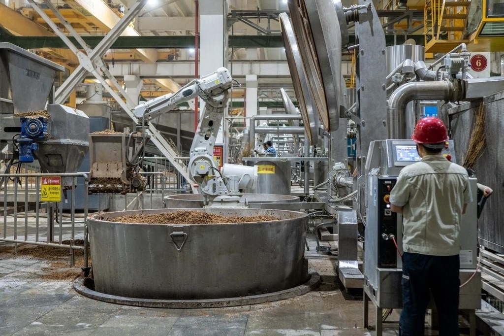 907車間里，機械臂正在撒料裝甑。嚴(yán)磊攝