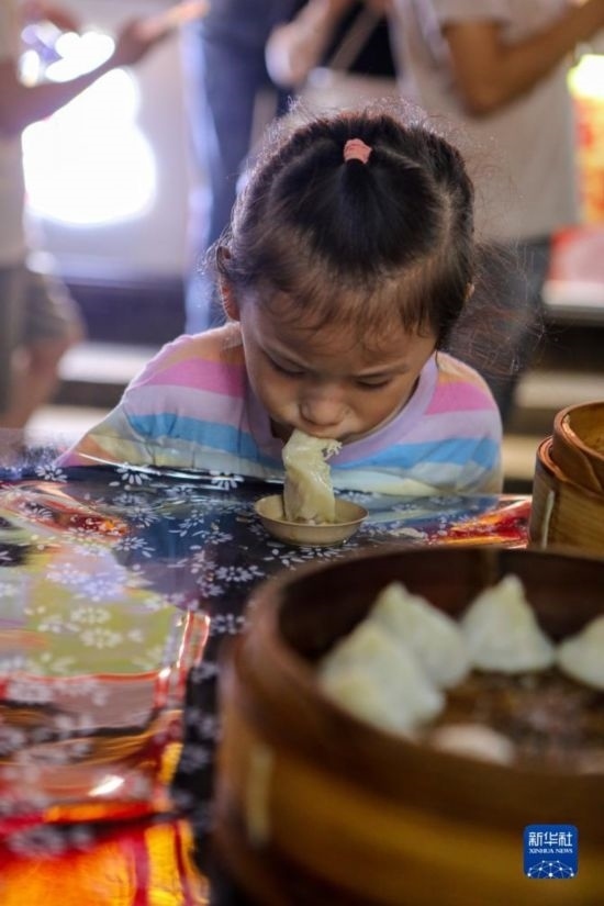 9月27日，小朋友在南翔小籠長街宴上品嘗南翔小籠。