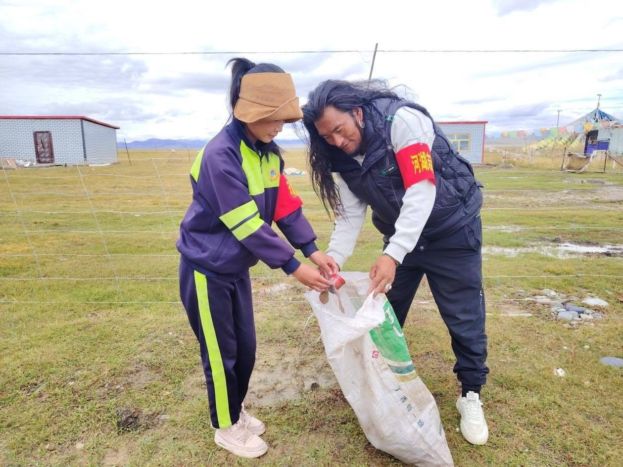 玉樹州稱多縣珍秦鎮(zhèn)河湖志愿者才培和他女兒更求拉毛在清掃垃圾。受訪者供圖