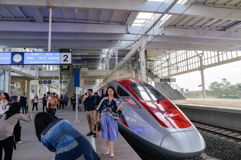 10月17日，在印度尼西亞萬(wàn)隆德卡魯爾站，乘客在站臺(tái)上和雅萬(wàn)高鐵高速動(dòng)車(chē)組列車(chē)合影。