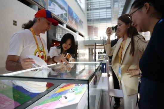 10月16日，參會記者在“一帶一路”國際合作高峰論壇新聞中心參觀展示的中國非物質文化遺產展品。新華社記者 陳斌 攝