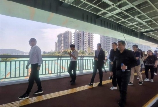 10月24日，2023“一帶一路”媒體合作論壇聯(lián)合采訪團(tuán)團(tuán)員走在清水塘大橋景觀通道上。本報記者 常雯宜攝