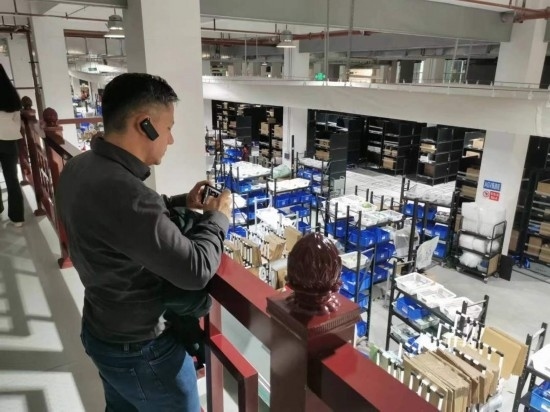 2023“一帶一路”媒體合作論壇聯(lián)合采訪團團員在仁和醫(yī)藥物流園拍攝記錄轉運流程。（本報記者 黃超攝）