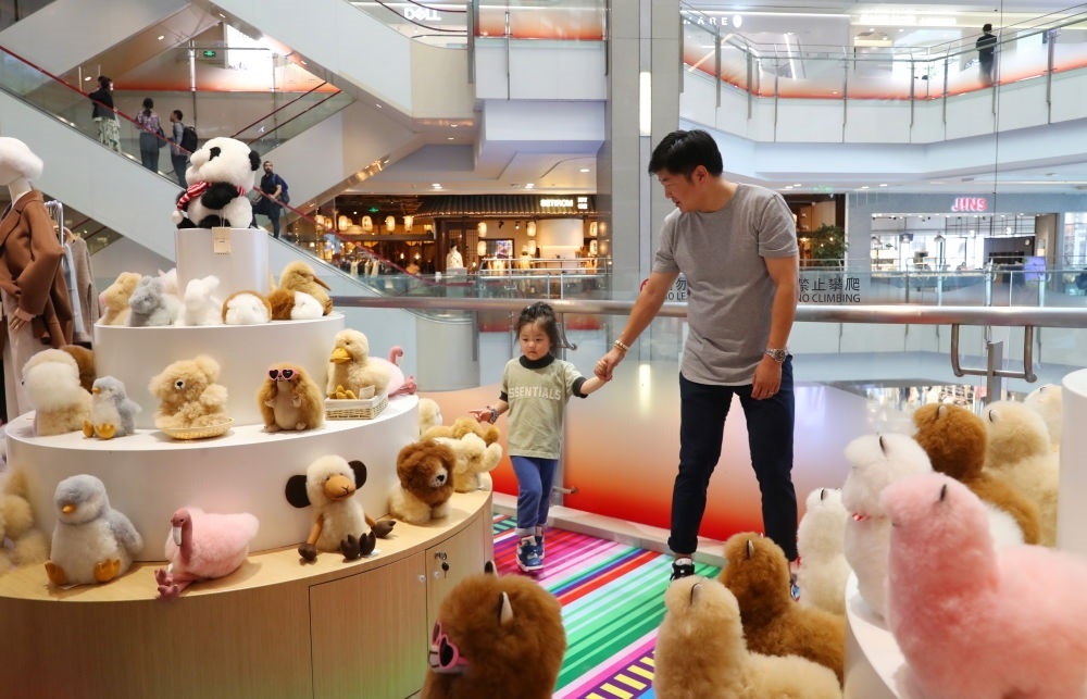 2023年11月2日，顧客在溫暖駝品牌專柜內(nèi)選購。連續(xù)六年參加進(jìn)博會的秘魯羊駝制品品牌溫暖駝在上海市中心商場開設(shè)了專柜。新華社記者 方喆 攝