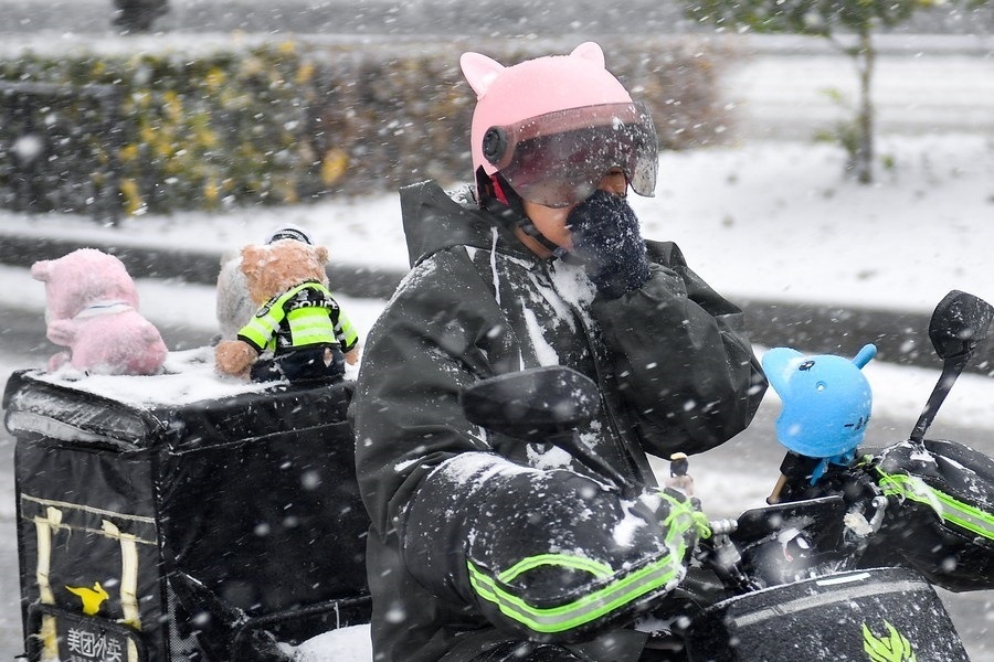 11月6日，在長(zhǎng)春市街頭，一名外賣(mài)員在雪中騎行。新華社記者 許暢 攝