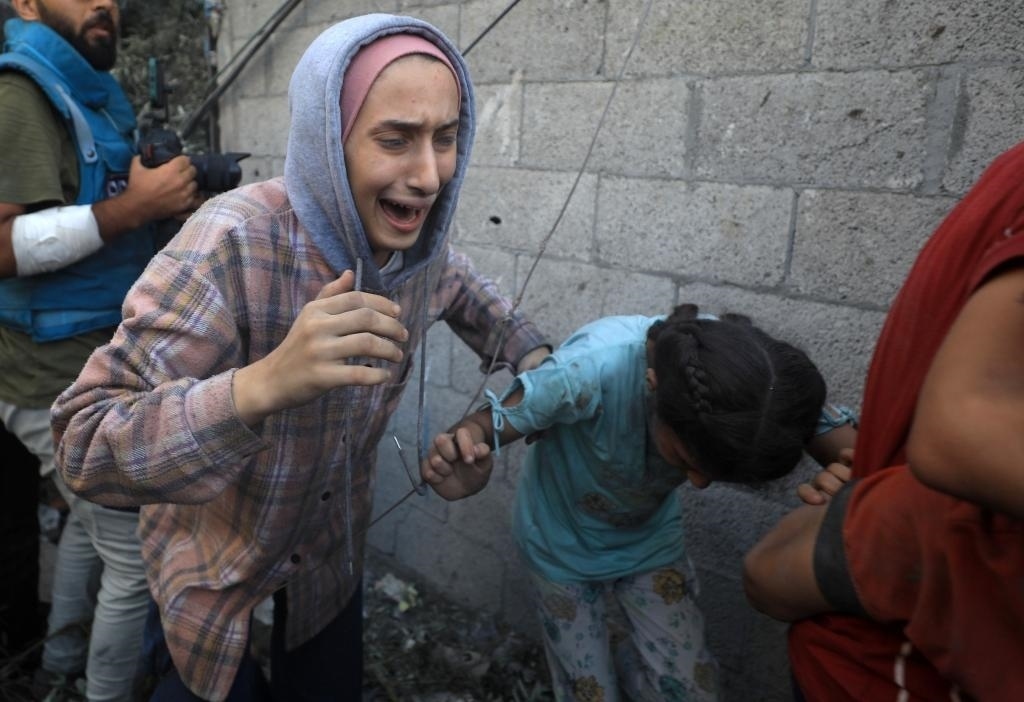 11月6日，人們從加沙地帶中部地區(qū)一處被炸難民營逃離。新華社發(fā)（亞西爾·庫迪攝）