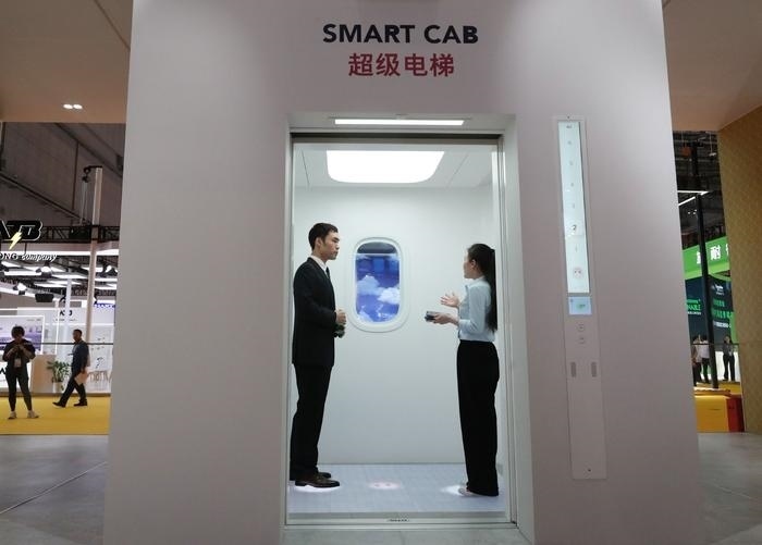 11月5日，工作人員（右）在第六屆進(jìn)博會(huì)上向參觀者介紹奧的斯公司全新推出的超級(jí)電梯。