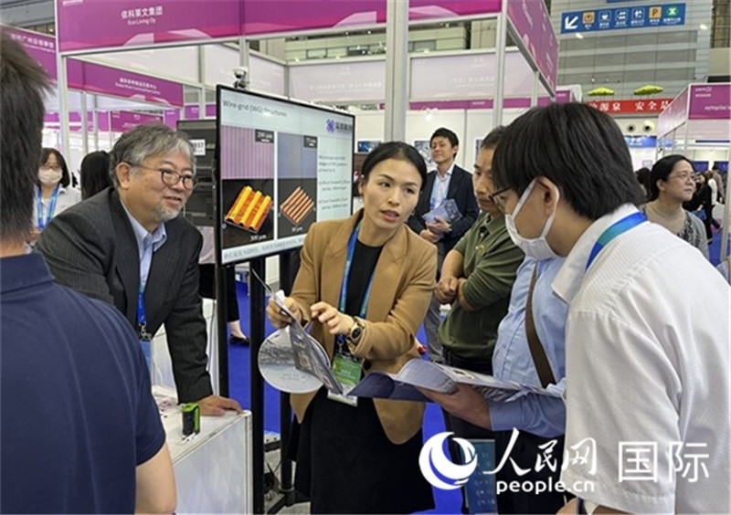 工作人員向參觀者介紹超級噴墨技術(shù)。（人民網(wǎng)記者 陳思攝）