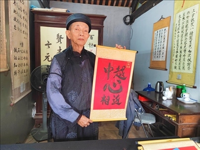 越南首都河內(nèi)文廟內(nèi)，阮明珠展示“中越心相近”書法作品。
