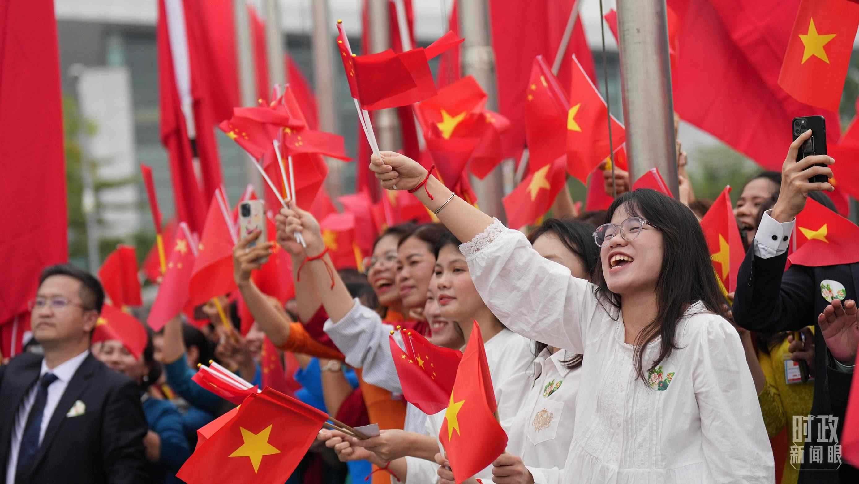 △人們揮舞兩國旗幟歡迎習(xí)近平訪越。（總臺(tái)國廣記者李晉拍攝）