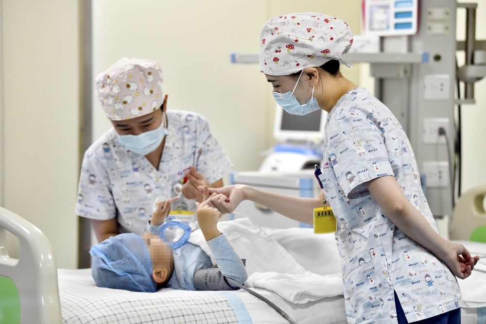 在山東省棗莊市婦幼保健院兒童ICU病房，醫(yī)護(hù)人員為完成靶向治療藥物諾西那生鈉的4歲脊髓性肌萎縮癥患兒加油鼓勁（2022年1月1日攝）。諾西那生鈉注射液是我國(guó)首個(gè)獲批治療脊髓性肌萎縮癥的進(jìn)口藥物，2019年進(jìn)入中國(guó)市場(chǎng)時(shí)，每針價(jià)格近70萬(wàn)元。在2021年國(guó)家醫(yī)保目錄藥品談判中，以3.3萬(wàn)元每針的價(jià)格進(jìn)入新版醫(yī)保藥品目錄。新華社記者 郭緒雷 攝