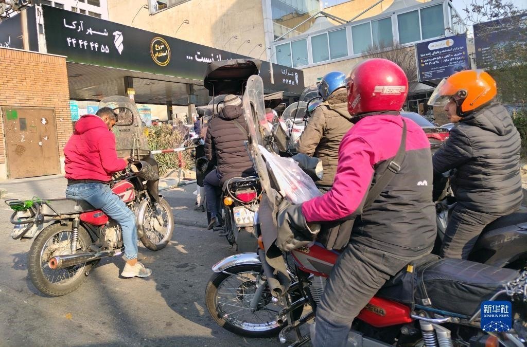 12月18日，摩托車在伊朗首都德黑蘭的一家加油站外等待加油。新華社記者 沙達(dá)提 攝