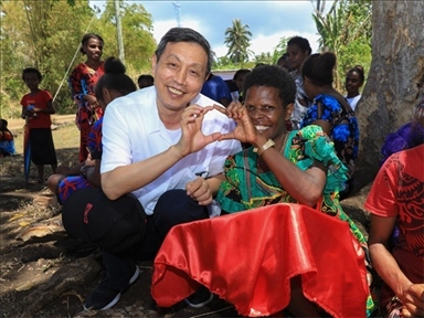 2023年12月18日，中國駐瓦努阿圖大使李名剛和前來觀看瓦努阿圖公路項目二期馬勒庫拉段移交儀式的當(dāng)?shù)鼐用窈嫌?。人民網(wǎng) 賀吉攝