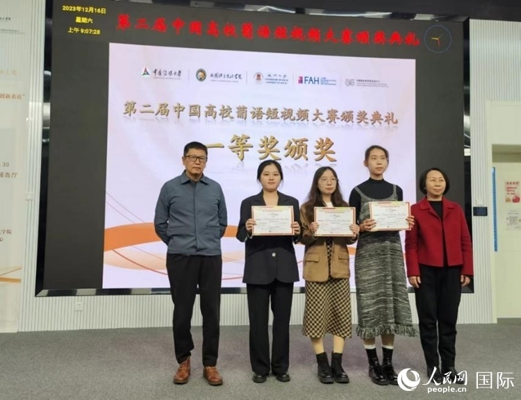 澳門大學中葡雙語教學暨培訓中心主任姚京明（左一）和中國傳媒大學外國語言文化學院院長文春英（右一）為一等獎獲得者頒獎。人民網(wǎng)記者 魯揚攝