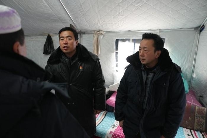 2023年12月22日，積石山縣大河家鎮(zhèn)大河村黨支部書記馬成忠（右二）在帳篷里和受災(zāi)群眾交流。新華社記者 陳斌 攝