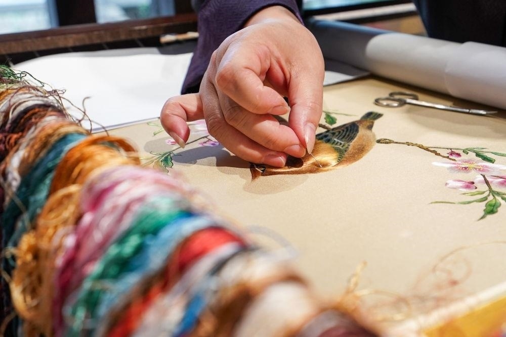 △2023年7月6日，盧建英在江蘇蘇州平江路的工作室內(nèi)刺繡。