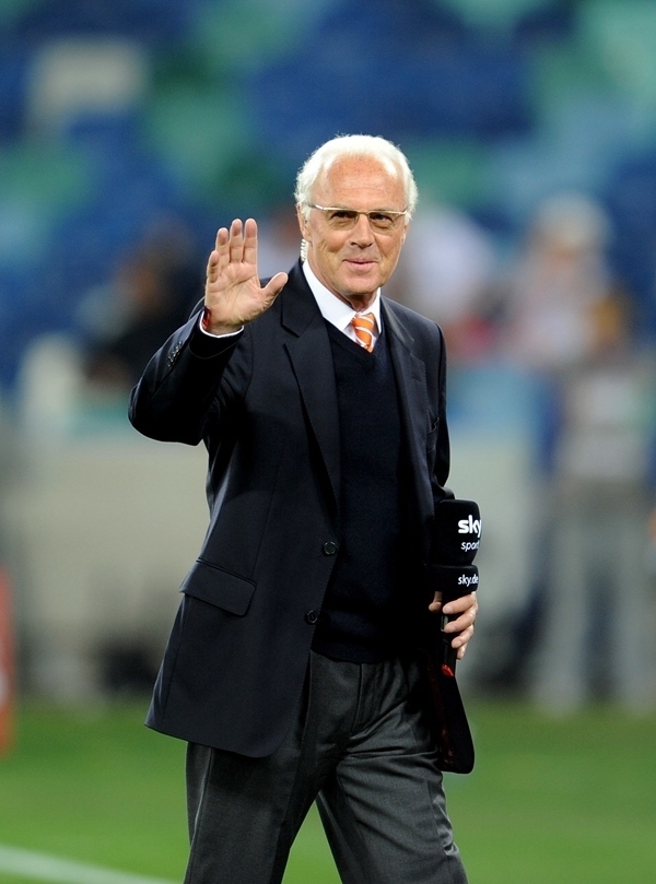 這是2010年7月7日，在南非德班舉行的2010年足球世界杯德國隊對陣西班牙隊的半決賽前，貝肯鮑爾接受電視臺采訪時和友人打招呼。新華社記者 王毓國 攝