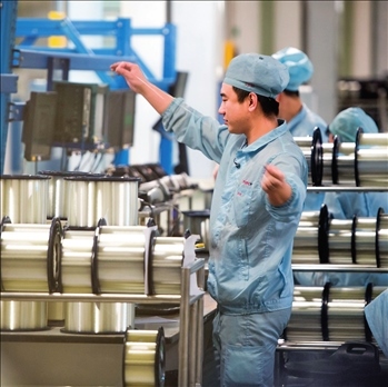 在位于武漢的長飛光纖光纜股份有限公司光纖生產(chǎn)車間內(nèi)，工作人員對光纖進(jìn)行檢測（資料圖片）。肖藝九攝/本刊